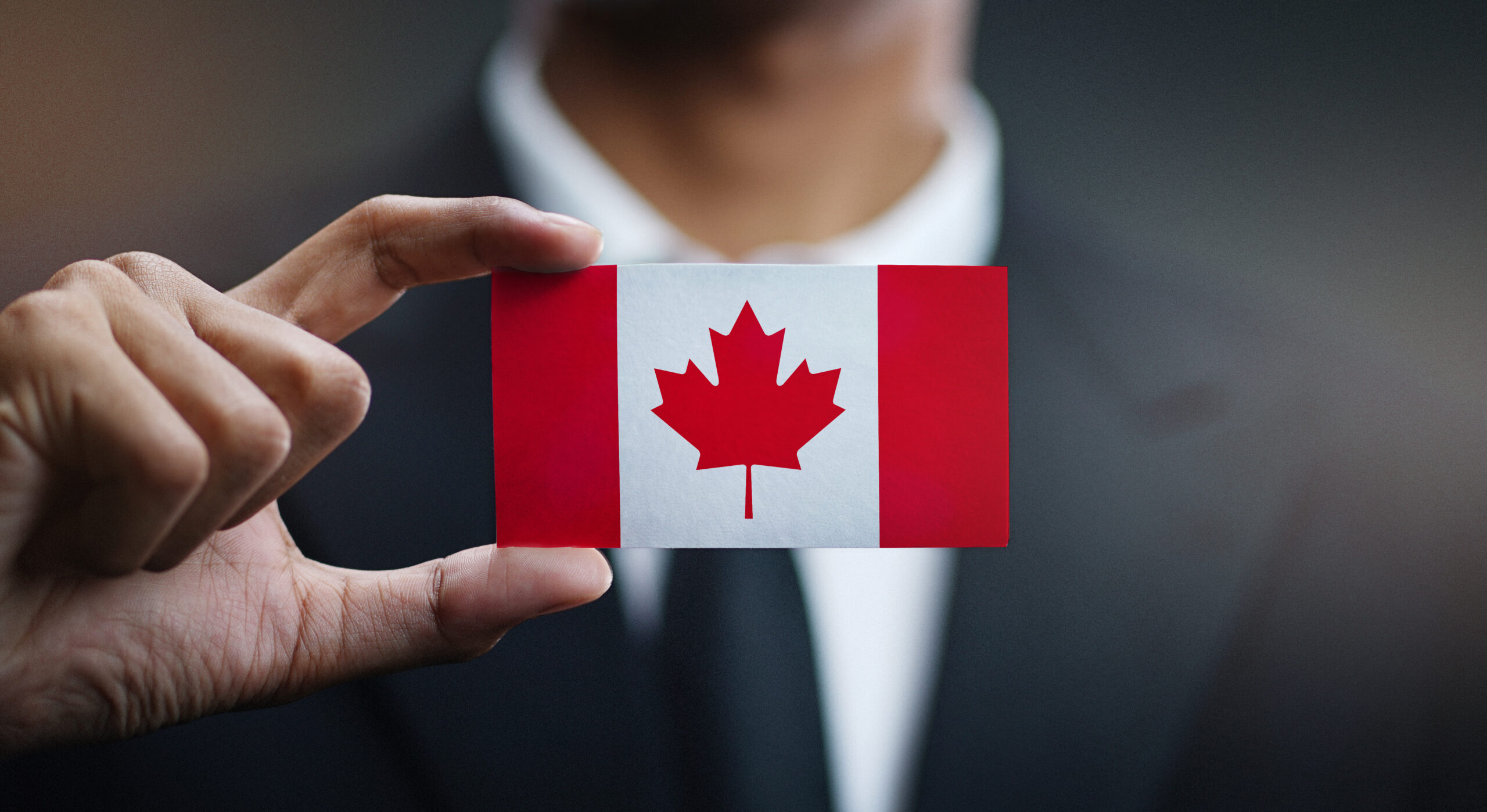 Businessman Holding Card of Canada Flag